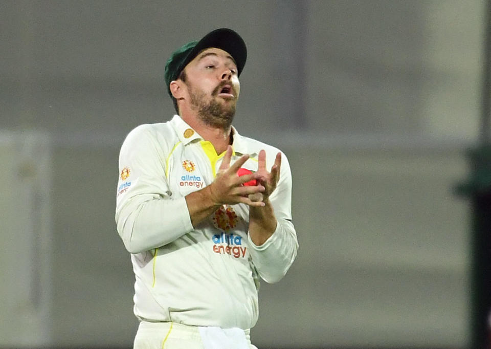 Australian cricketer Travis Head on the money, catching a ball during a Test match.