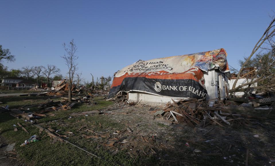 A tornado-damaged home is covered by tarps in Baxter Springs, Kan., Monday, April 28, 2014. The tornado left a trail of shattered homes, twisted metal and hanging power lines. One person died, but it was not clear whether the death was related to the storm. Volunteers were meeting early Monday to discuss cleanup efforts. Emergency officials say 60 to 70 homes and 20 to 25 businesses were destroyed or damaged in the town. (AP Photo/Orlin Wagner)