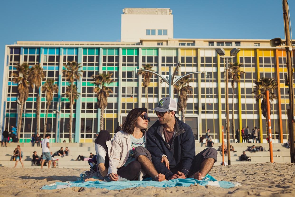 Alec Burkin, son of Alice Braunstein of Narragansett, sits with his partner, Danielle Haliva, on a beach in Tel Aviv in a different era - before Hamas gunman slaughtered Israeli families and took hostages in Israeli towns near the Gaza Strip earlier this month.