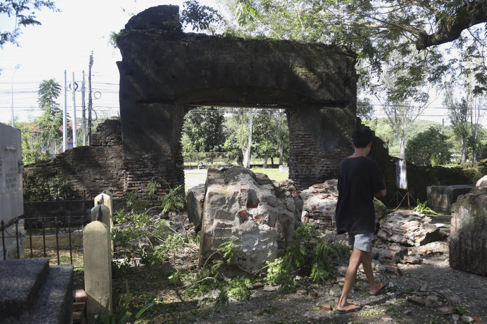 A man walks beside a damaged wall after a strong earthquake at Ilocos Norte, Northern Philippines on Wednesday Oct. 26, 2022. A strong earthquake rocked a large swathe of the northern Philippines, injuring multiple people and forcing the closure of an international airport and the evacuation of patients in a hospital, officials said Wednesday. (AP Photo)