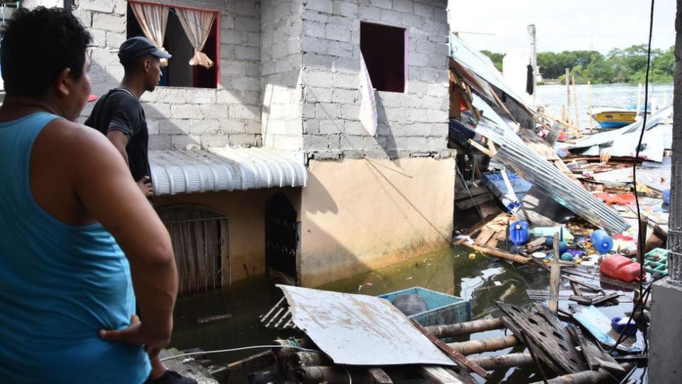 gente mirando casas destruidas