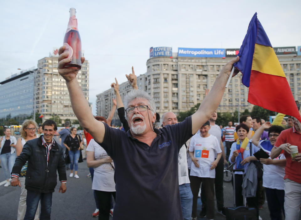 A man shouts as hundreds celebrate the sentencing to prison of Liviu Dragnea, the leader of the ruling Social Democratic party, outside the government headquarters in Bucharest, Romania, Monday, May 27, 2019. Romania's most powerful politician was sentenced Monday to 3 and a half years in prison for official misconduct in a graft case. (AP Photo/Vadim Ghirda)