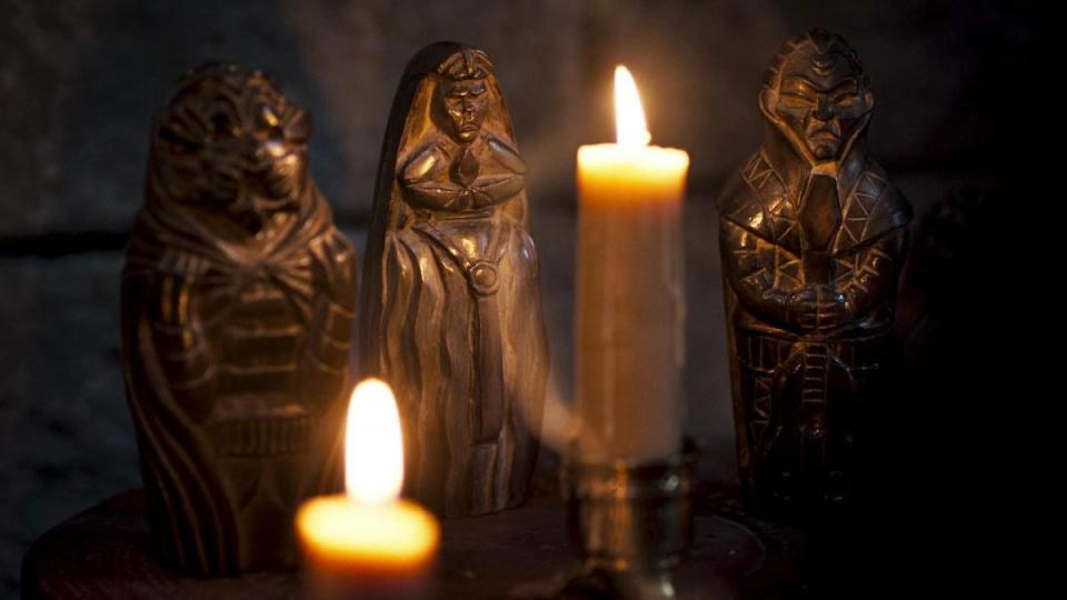 Statues of the Forsaken in the Wheel of Time, lit by candlelight