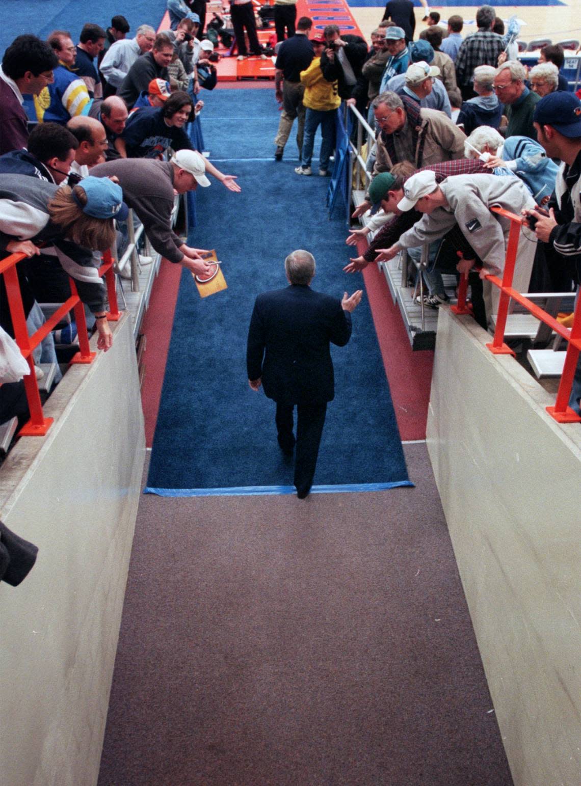 UNC head coach, Dean Smith, heads onto the court to face Louisville in the 1997 NCAA East regionals in Syracuse, NY.