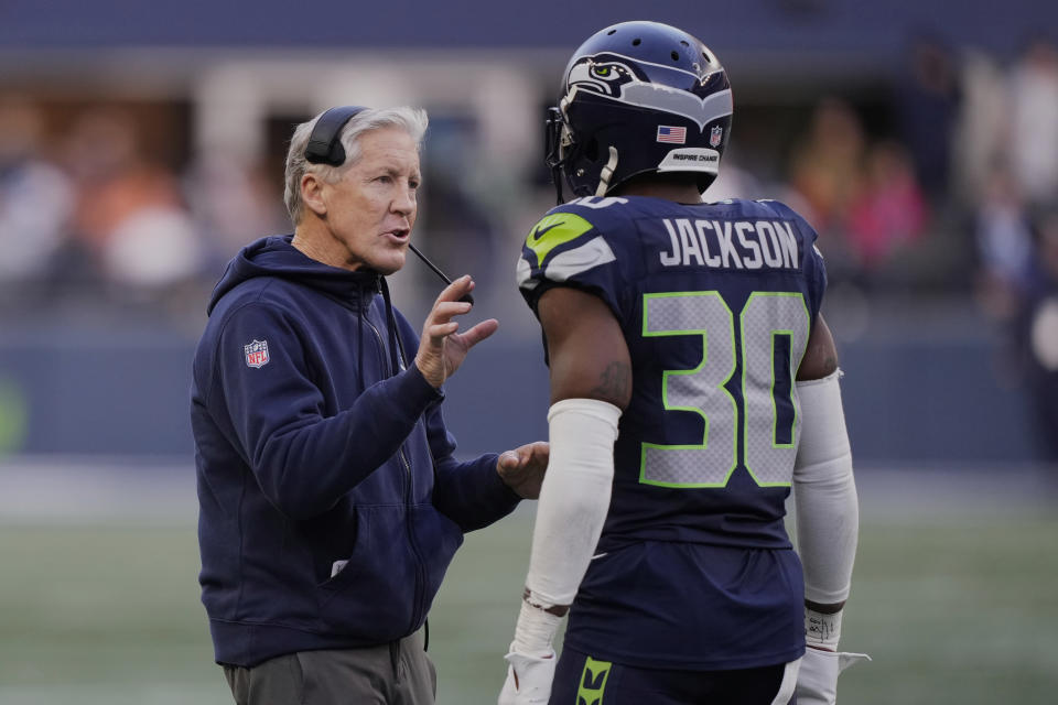 Seattle Seahawks head coach Pete Carroll talks to cornerback Michael Jackson (30) in the first half of an NFL football game against the Pittsburgh Steelers Sunday, Dec. 31, 2023, in Seattle. (AP Photo/Stephen Brashear)