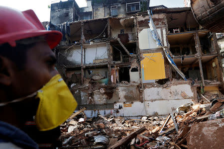 A rescue worker searches for survivors at the site of a collapsed building in Mumbai, September 1, 2017. REUTERS/Shailesh Andrade