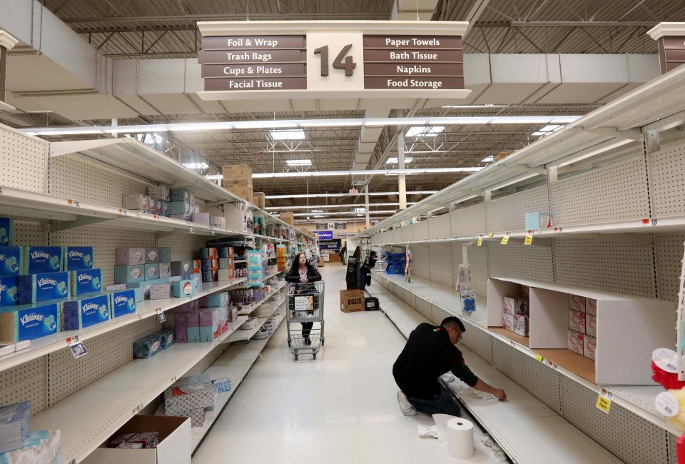 With stocks running low at grocery stores throughout the nation to due to coronavirus concerns, an employee cleans bare shelves at the Stop & Shop supermarket in Tarrytown, N.Y. March 15, 2020. 