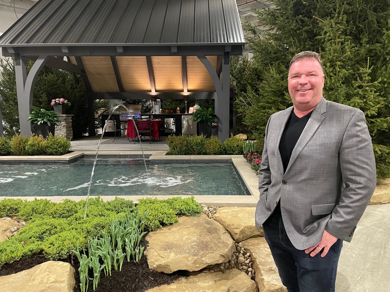 Jacob Grimm, of Brothers Grimm Landscape & Design Co. in Akron,  stands in front of his "Ferris Buehler's Day Off" inspired garden that won third place at this year's Great Big Home + Garden show at the I-X Center in Cleveland/