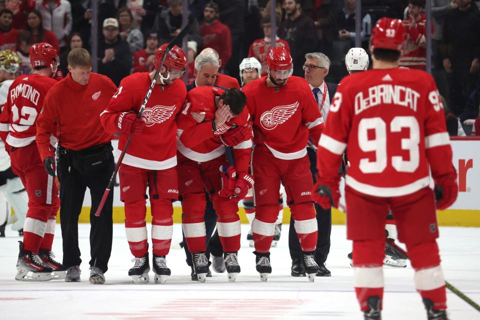 Dylan Larkin of the Detroit Red Wings is helped off the ice by teammates after being injured in the first period while playing the Ottawa Senators at Little Caesars Arena on Dec. 9, 2023, in Detroit, Michigan.