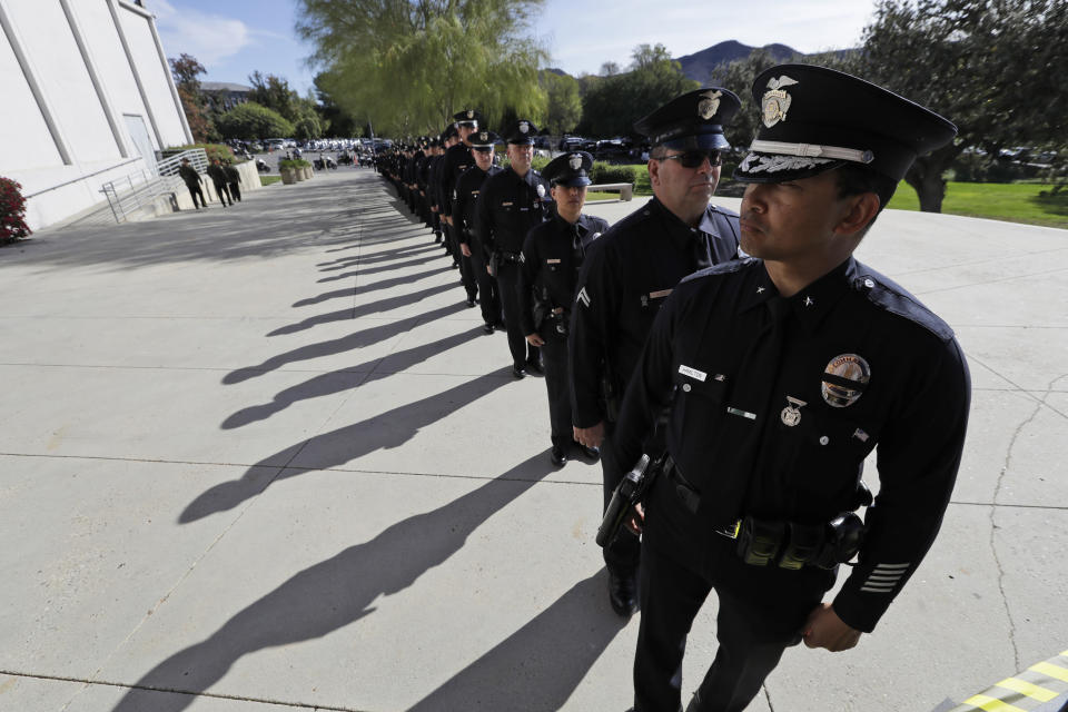Police officers enter the the Calvary Community Church for a service in memory of Ventura County Sheriff's Sgt. Ron Helus at Thursday, Nov. 15, 2018, in Westlake Village, Calif. Helus was fatally shot while responding to a mass shooting at a country music bar in Southern California. (AP Photo/Marcio Jose Sanchez, Pool)