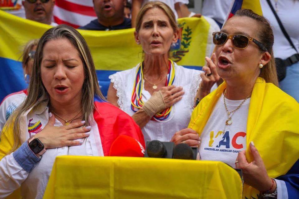 Nerlitt Torres, izquierda, presidenta de la fundación Blanco Nieves Sierra, y Adelys Ferro, directora ejecutiva del Venezuelan American Caucus, derecha, encabezan la entonación del Himno Nacional de Venezuela durante la manifestación por el derecho al voto en las elecciones venezolanas. Un grupo de unas sesenta personas se reunió en el antiguo consulado venezolano en protesta por su negativa a votar en las elecciones venezolanas el domingo 28 de julio de 2024, en Miami, Florida.