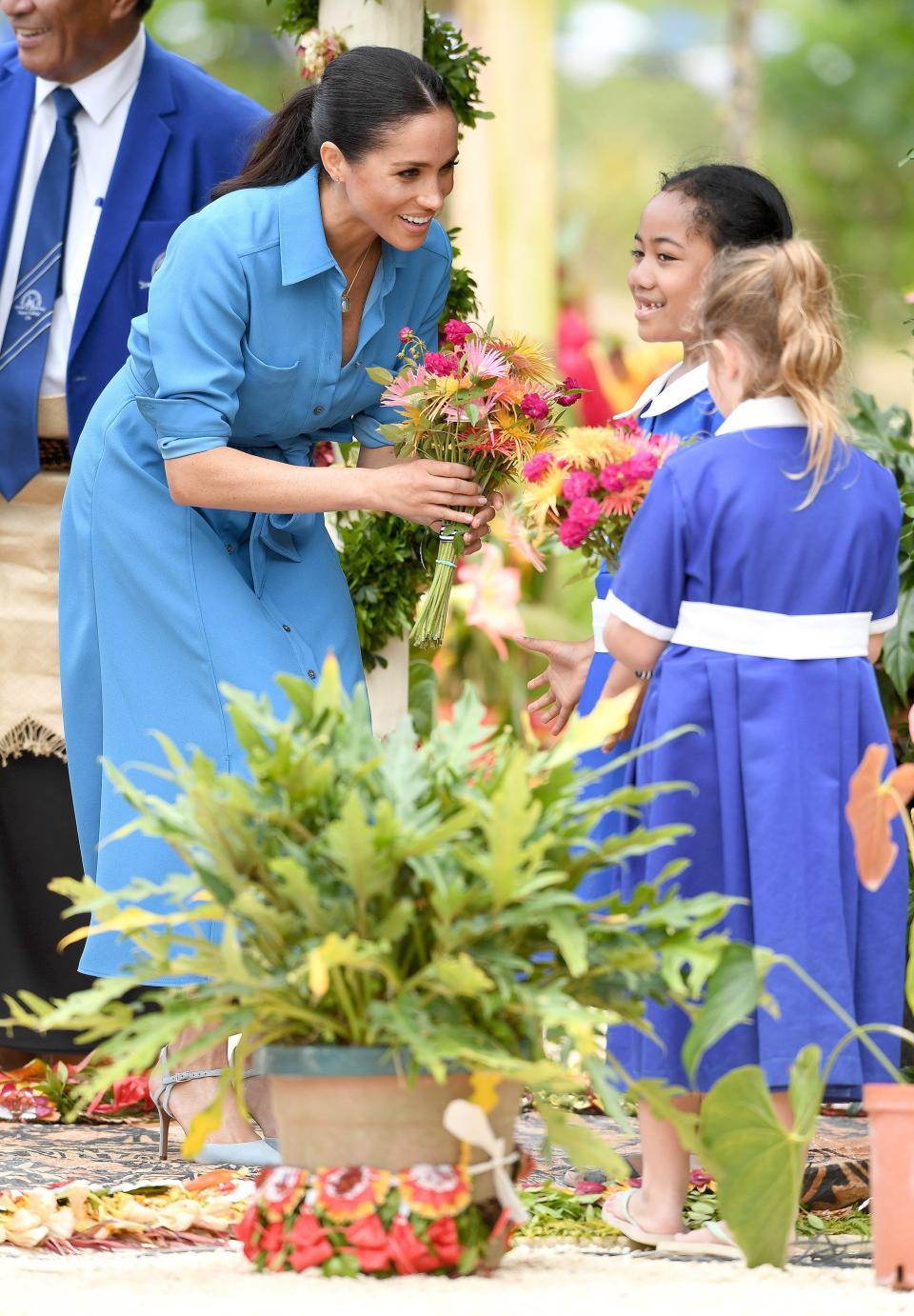 The only thing brighter than Meghan's dress was her smile when she met with two little girls while visiing Tupou College in Nuku'alofa, Tonga, in October.