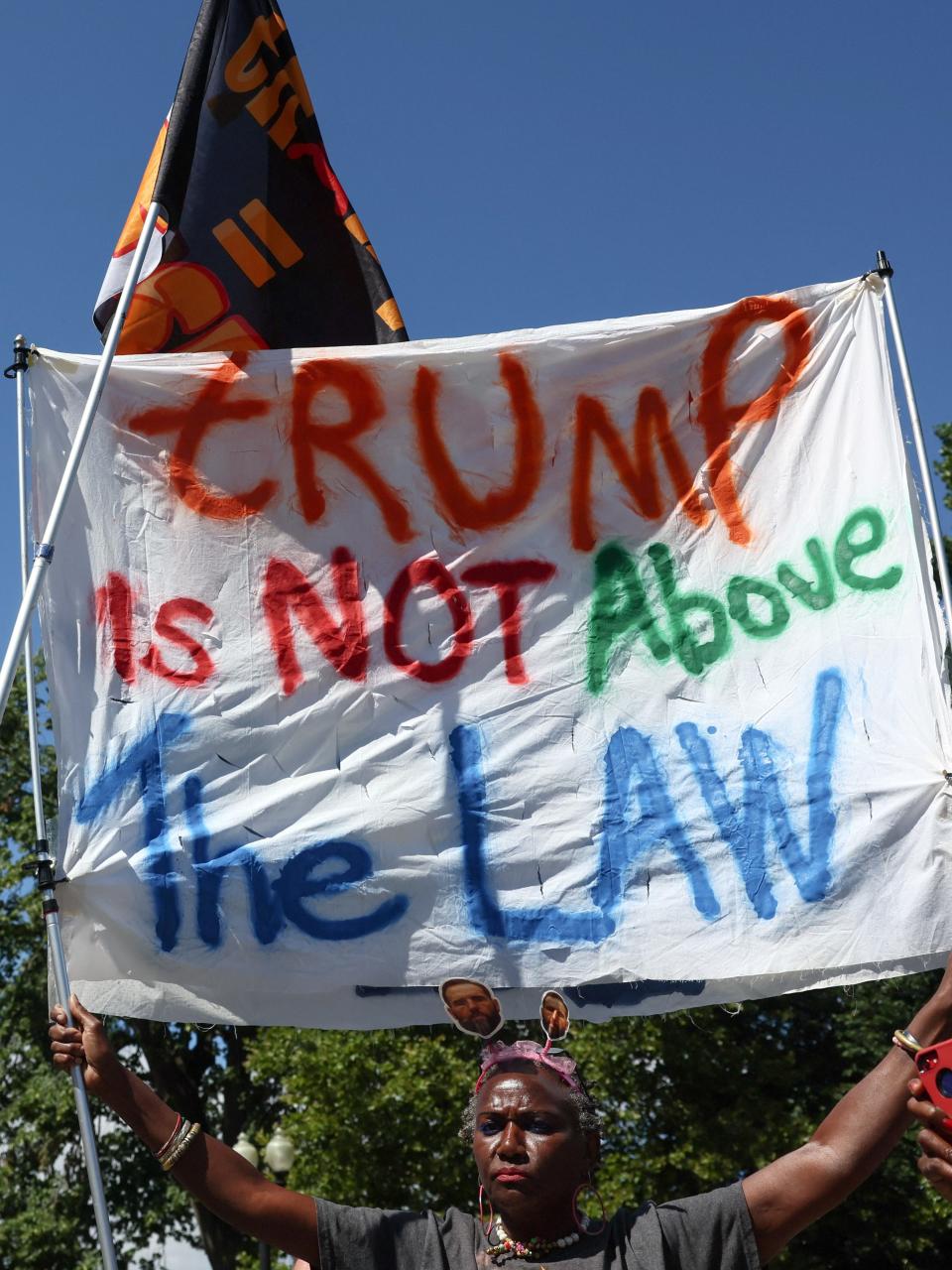 Nadine Seiler holds a banner outside the Supreme Court after justices ruled on former President and Republican presidential candidate Donald Trump's request for immunity from federal prosecution for undermining the 2020 election on July 1, 2024, in Washington.