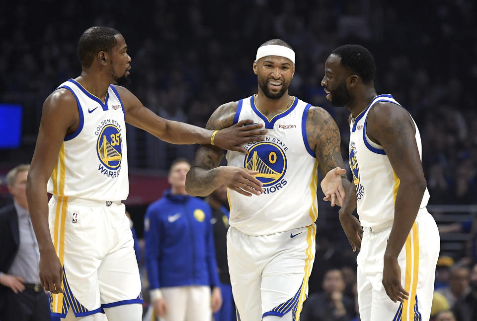 Golden State Warriors forward Kevin Durant, left, pats center DeMarcus Cousins, center, on the chest as forward Draymond Green smiles during the first half of the team's NBA basketball game against the Los Angeles Clippers on Friday, Jan. 18, 2019, in Los Angeles. (AP Photo/Mark J. Terrill)
