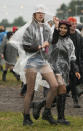 Festivalgoers shelters from the pouring rain on the first day of Download Festival at Donington Park at Castle Donington, England, Friday June 18, 2021. The three-day music and arts festival is being held as a test event to examine how Covid-19 transmission takes place in crowds, with the the capacity significantly reduced from the normal numbers. (Joe Giddens/PA via AP)