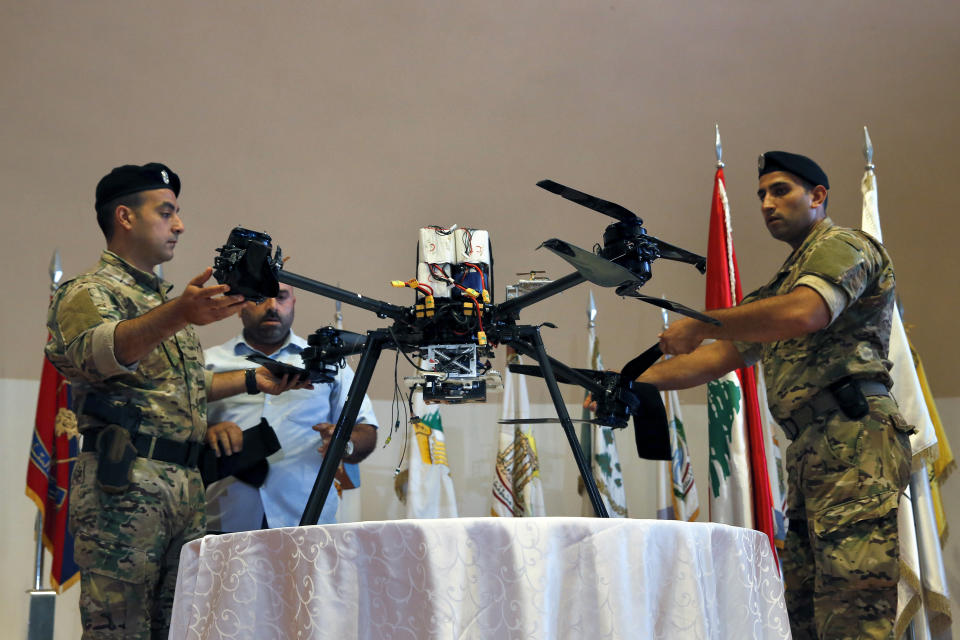 Lebanese Army soldiers show journalists an Israeli drone that crashed in southern Beirut last month during a press conference to announce the results of an investigation into the incident, at the Lebanese Defense Ministry, in Yarzeh near Beirut, Lebanon, Thursday, Sept. 19, 2019. The investigation has concluded that two Israeli drones that crashed in the Lebanese capital last month were on an attack mission, one of them armed with 4.5 kilograms of explosives. (AP Photo/Bilal Hussein)