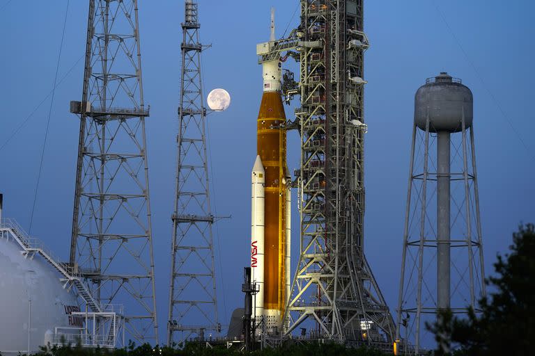 Con la Luna de fondo, el cohete del programa Artemisa de la NASA con la cápsula Orión en la parte superior permanece en la plataforma 39B del Centro Espacial Kennedy