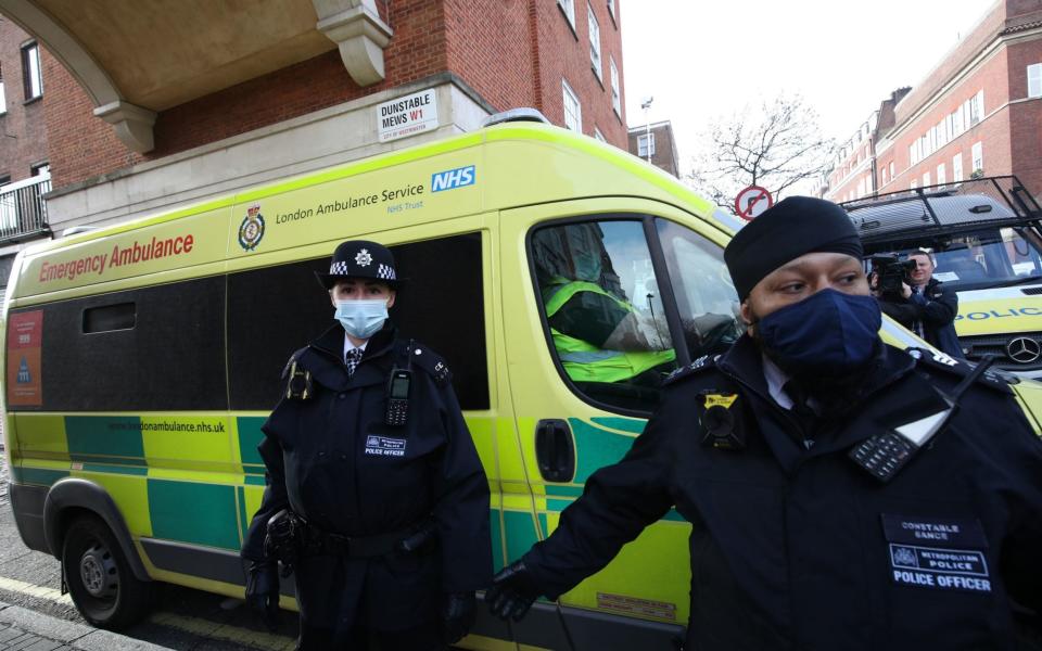 Police officers and security guards clear a pathway for an ambulance as it leaves the rear of the King Edward VII Hospital - PA