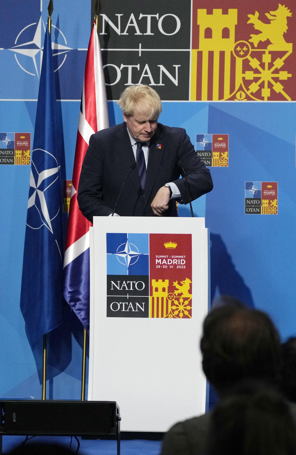 British Prime Minister Boris Johnson looks at his watch as he prepares to address a media conference at a NATO summit in Madrid, Spain on Thursday, June 30, 2022. North Atlantic Treaty Organization heads of state met for the final day of a NATO summit in Madrid on Thursday. (AP Photo/Paul White)