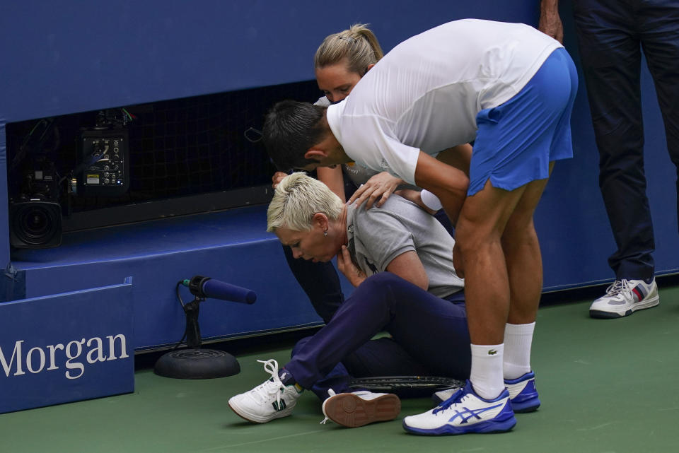 Novak Djokovic atiende a la jueza de línea tras haberla impacto con un pelotazo durante el partido de cuartos de final contra Pablo Carreño Busta en el Abierto de Estados Unidos, el domingo 6 de septiembre de 2020, en Nueva York. Djokovic fue descalificado. (AP Foto/Seth Wenig)