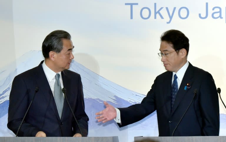 Japanese Foreign Minister Fumio Kishida (R) prepares to shake hands with Chinese Foreign Minister Wang Yi after a press conference in Tokyo on August 24, 2016