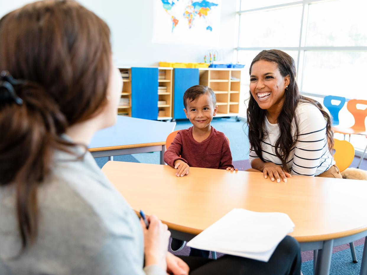 Cute boy watches mom and teacher in meeting