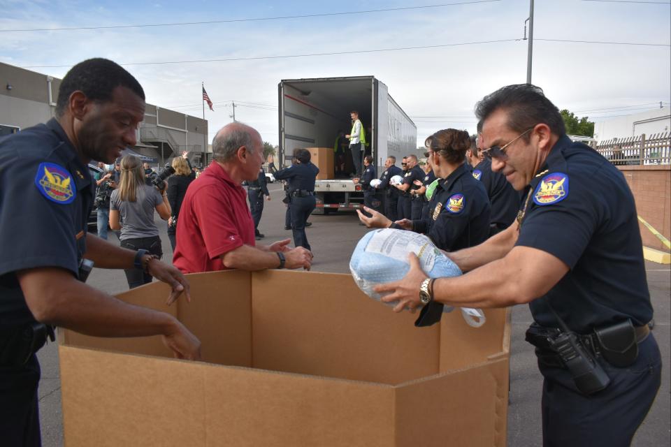 Officers and volunteers with Phoenix Police Department's Desert Horizon Precinct deliver turkeys to St. Mary's Food Bank on Nov. 23, 2021.
