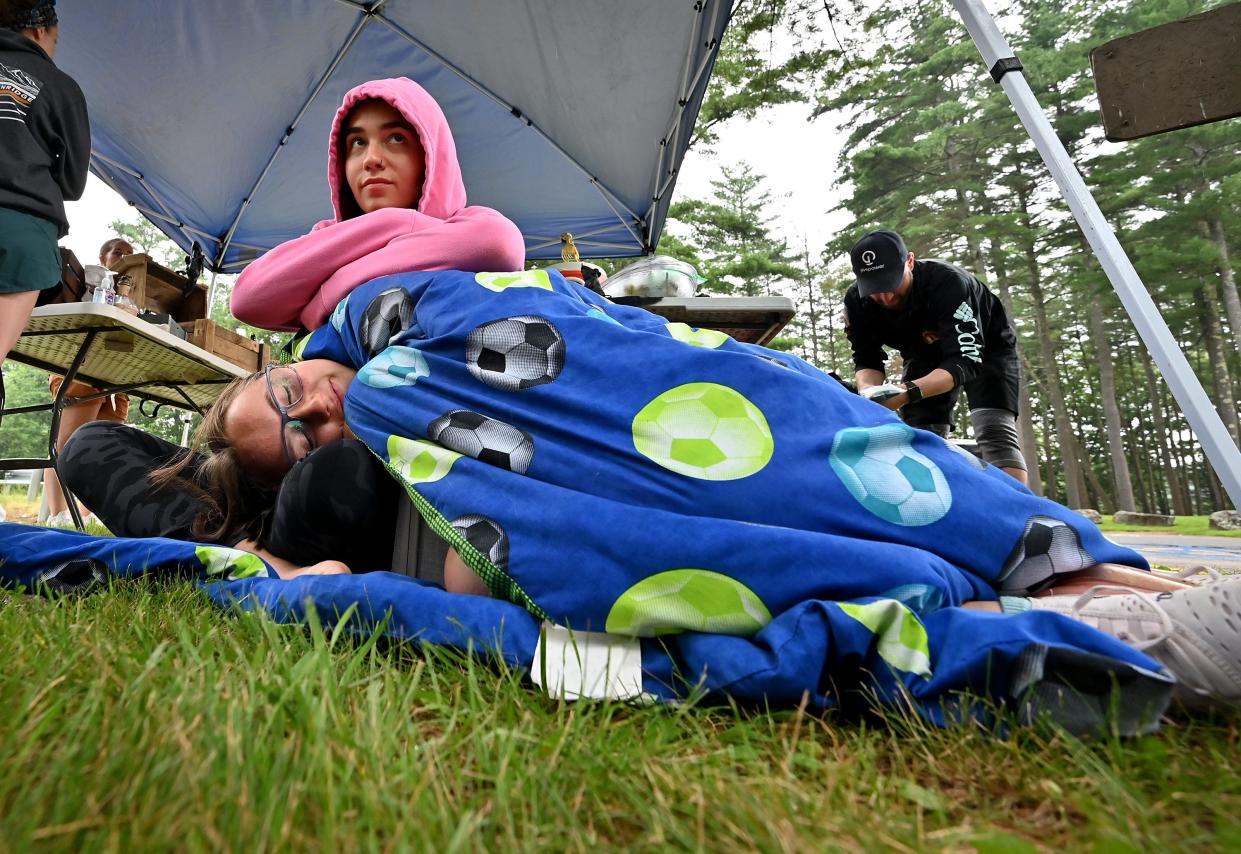 Why Me kid Samantha Dube, 17, of Oakham snuggles under a blanket at the Barre Falls Dam aid station in Hubbardston as she and her sister, Allyson, 19, wait for their mother, Holly, who was rucking for the 100 Mile Ruck March Charity Challenge for Why Me & Sherry's House.