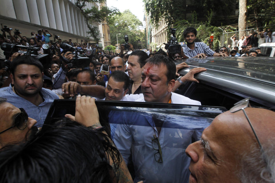 Bollywood star Sanjay Dutt, center, arrives to surrender before a court in Mumbai, India, Thursday, May 16, 2013. Dutt has been sentenced to five years in prison for a 1993 weapons conviction linked to a deadly terror attack in Mumbai that killed 257 people. The 53-year-old actor served 18 months in jail before being released on bail in 2007 pending an appeal. The Supreme Court reduced his prison sentence to five years from the six-year term initially handed down. (AP Photo/Rajanish Kakade)