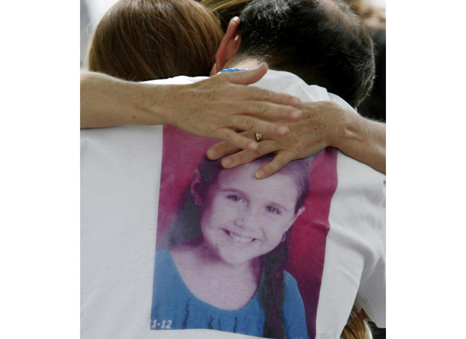 FILE - In this April 25, 2012, file photo, Sergio Celis, wearing a shirt with a picture of his missing 6-year-old daughter, Isabel, gets a hug from a volunteer near their home in Tucson, Ariz. Arizona officials say Christopher Matthew Clements was indicted on Friday, Sept. 14, 2018, in the kidnapping and killing of Isabel Celis in 2012 and 13-year-old Maribel Gonzalez in 2014. (A.E. Araiza/Arizona Daily Star via AP, File)