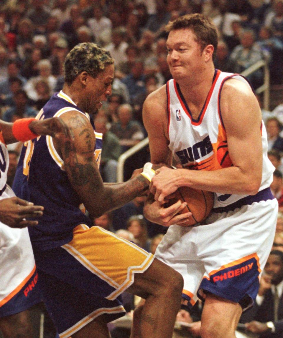 PHOENIX, AZ - MARCH 1: Los Angeles Lakers forward Dennis Rodman and Phoenix Suns center Luc Longley battle for possession during the second quarter 01 March at America West Arena in Phoenix,AZ. Rodman and Longley were members of last year's Chicago Bulls. The Lakers won 97-91. (Photo credit should read MIKE FIALA/AFP via Getty Images)