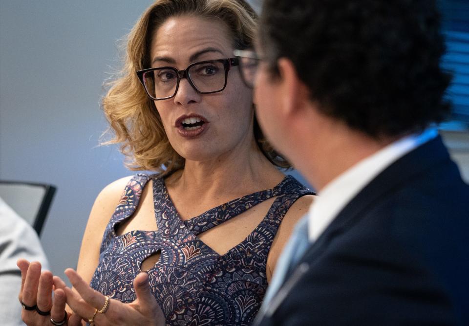 Sen. Kyrsten Sinema (left) speaks during a roundtable on gun violence on April 21, 2023, at Valley of the Sun United Way in Phoenix.