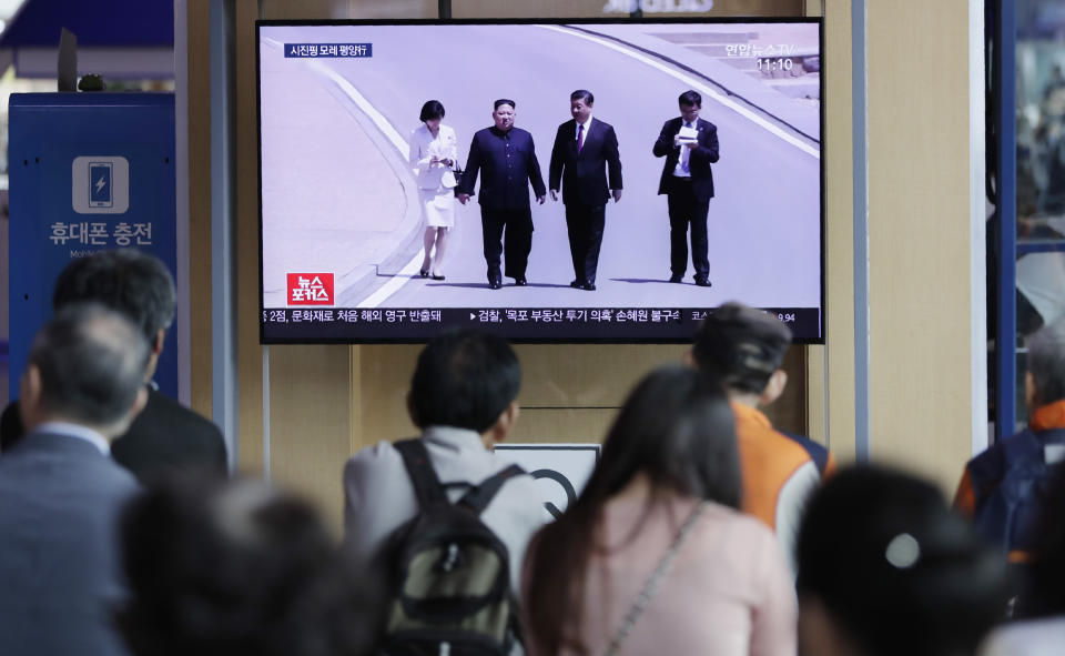 People watch a TV news program reporting about Chinese President Xi Jinping's state visit to North Korea with file footage of Xi and North Korean leader Kim Jong Un, at the Seoul Railway Station in Seoul, South Korea, Tuesday, June 18, 2019. The letters on the top read "Chinese President Xi Jinping will visit Pyongyang on June 20". (AP Photo/Lee Jin-man)