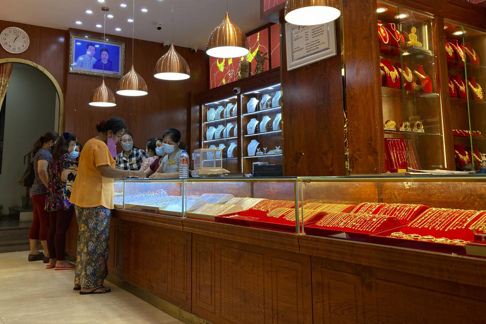 Customers browse items inside a jewelry store in Yangon, Myanmar on Nov. 9, 2021. The military takeover in Myanmar has set its economy back years, if not decades, as political unrest and violence disrupt banking, trade and livelihoods and millions slide deeper into poverty. (AP Photo)