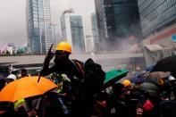 An anti-extradition bill protester reacts as he clashes with riot police during a march in Hong Kong