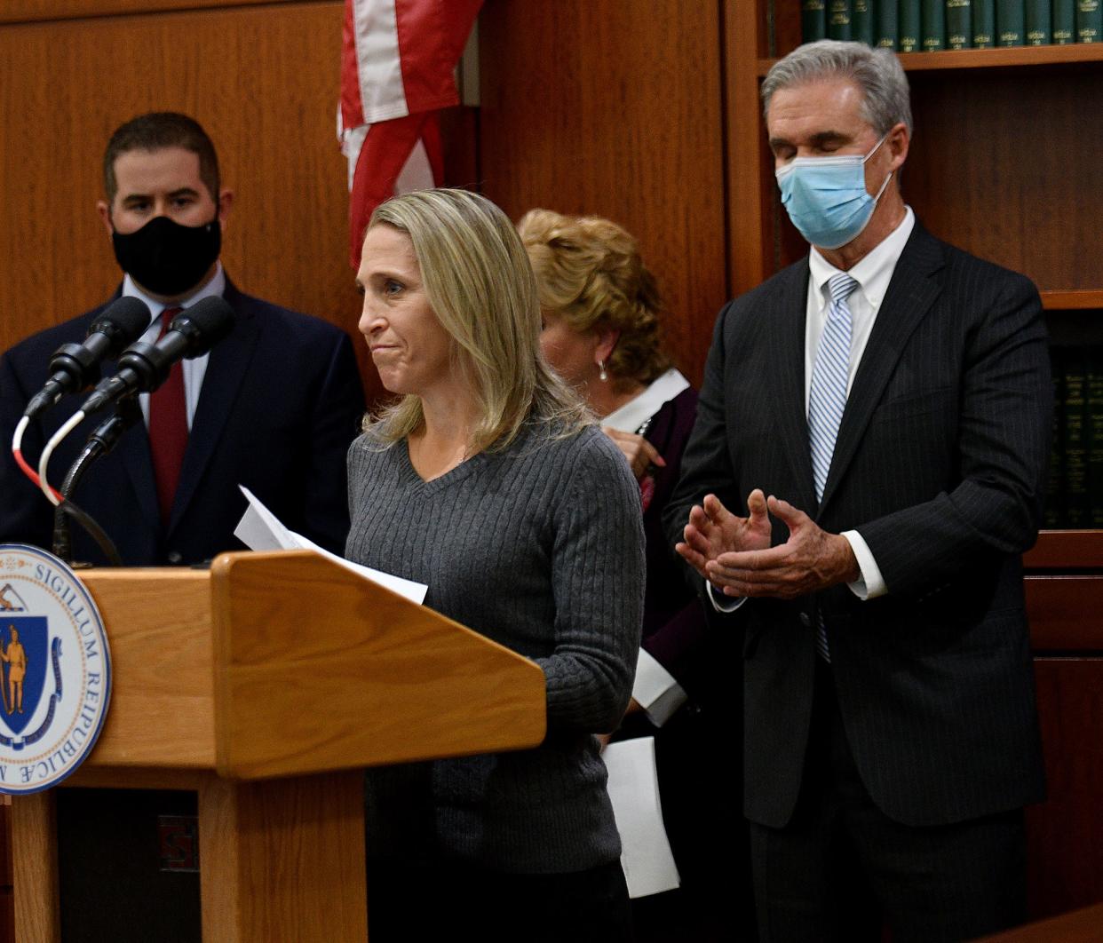 Reisa Clardy, widow of state trooper Thomas Clardy, speaks after Gov. Charlie Baker, in background, announced legislation to combat driving while high.