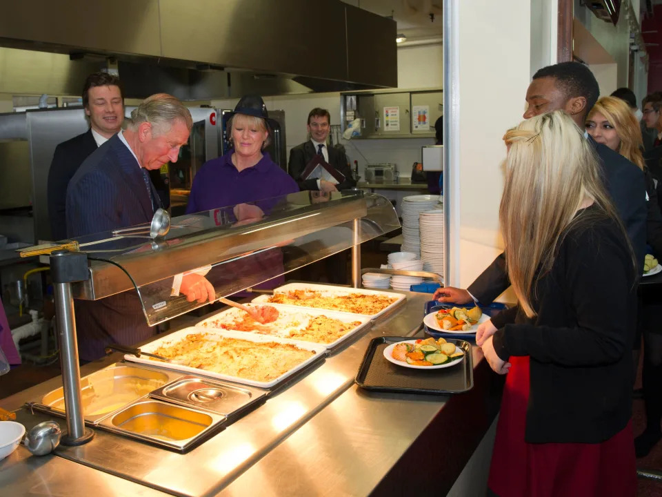 Prince Charles serves food at a cafeteria