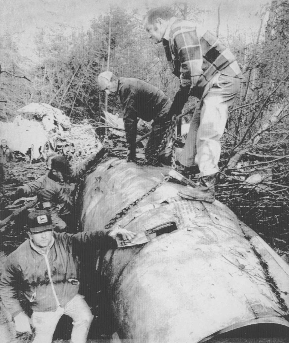 FILE - Officials at the site of the Nov. 14, 1970, Marshall University plane crash at Tri-State Airport in Kenova, W.Va., secure a charred engine for removal to an airport hangar. West Virginia could soon have a new holiday to memorialize 75 people killed in the Marshall University plane crash more than 50 years ago. Democratic Del. Sean Hornbuckle is the lead sponsor of the legislation, which passed the House Government Organization Committee on Monday, Jan. 16, 2023. (Jack Burnett/The Herald-Dispatch via AP)