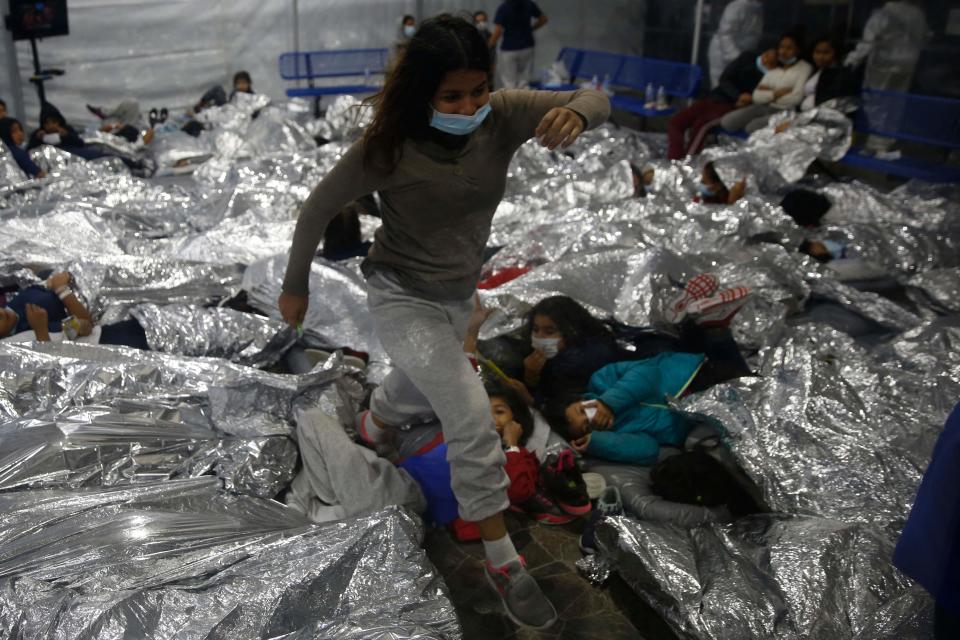 A girl steps over other girls in a pod at the Department of Homeland Security holding facility in Donna, Texas, on March 30. The facility is the main detention center for unaccompanied children in the Rio Grande Valley run by U.S. Customs and Border Protection.