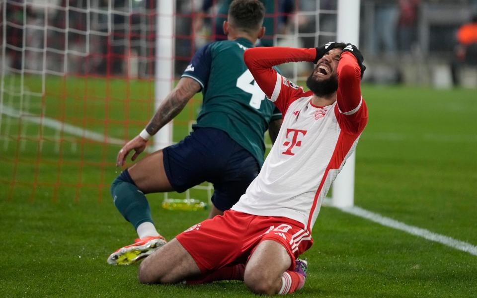 Noussair Mazraoui reacts to David Raya's save.