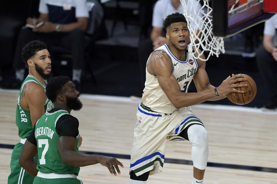 Milwaukee Bucks' Giannis Antetokounmpo, right, heads to the basket past Boston Celtics' Jaylen Brown (7) during the first half of an NBA basketball game Friday, July 31, 2020, in Lake Buena Vista, Fla. (AP Photo/Ashley Landis, Pool)