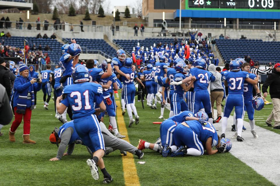 Clinton-Massie Falcons celebrate early on the sideline after gaining possession of the ball with 9 seconds left during the OHSAA Division IV State Final game between the Clinton-Massie Falcons and the Ursuline Fighting Irish at the Tom Benson Hall of Fame stadium on Friday Dec. 3, 2021. The Clinton-Massie Falcons won the game with a final score of 29-28.