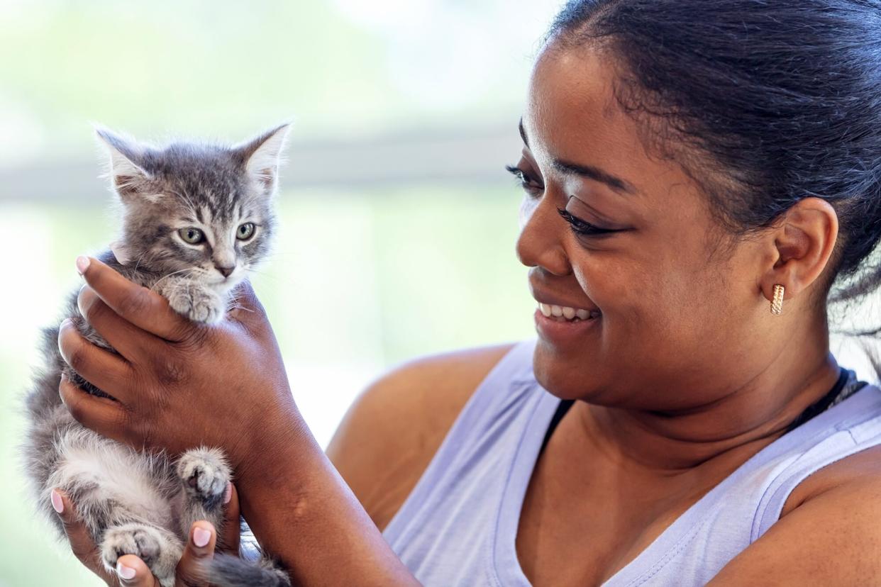 woman holding small kitten