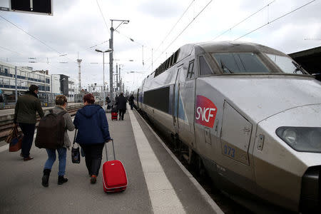 Commuters walks past a TGV high speed train at a railway station in Nantes, France, March 21, 2018. REUTERS/Stephane Mahe