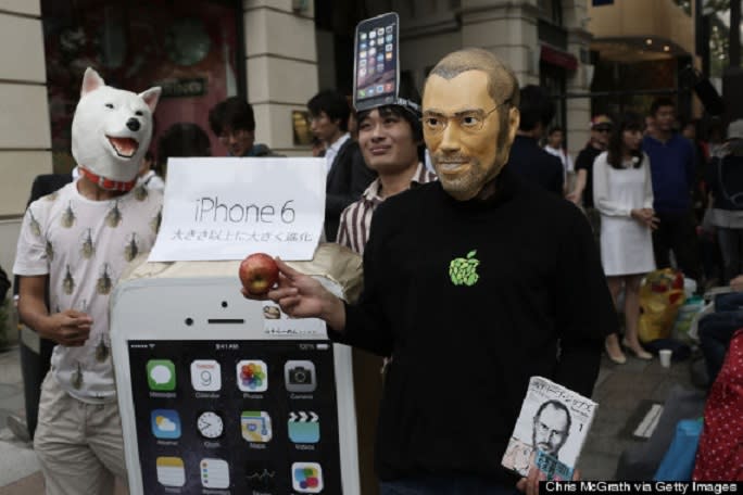 The Japanese are queuing to get the latest iPhone with Steve Jobs mask and an apple. Image credit: Huffington Post