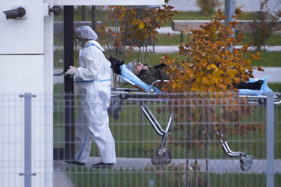 A medical worker carries a patient suspected of having coronavirus on a stretcher at a hospital in Kommunarka, outside Moscow, Russia, Saturday, Oct. 16, 2021. Russia's daily death toll from COVID-19 has exceeded 1000 for the first time as the country faces a sustained wave of rising infections. (AP Photo/Alexander Zemlianichenko)