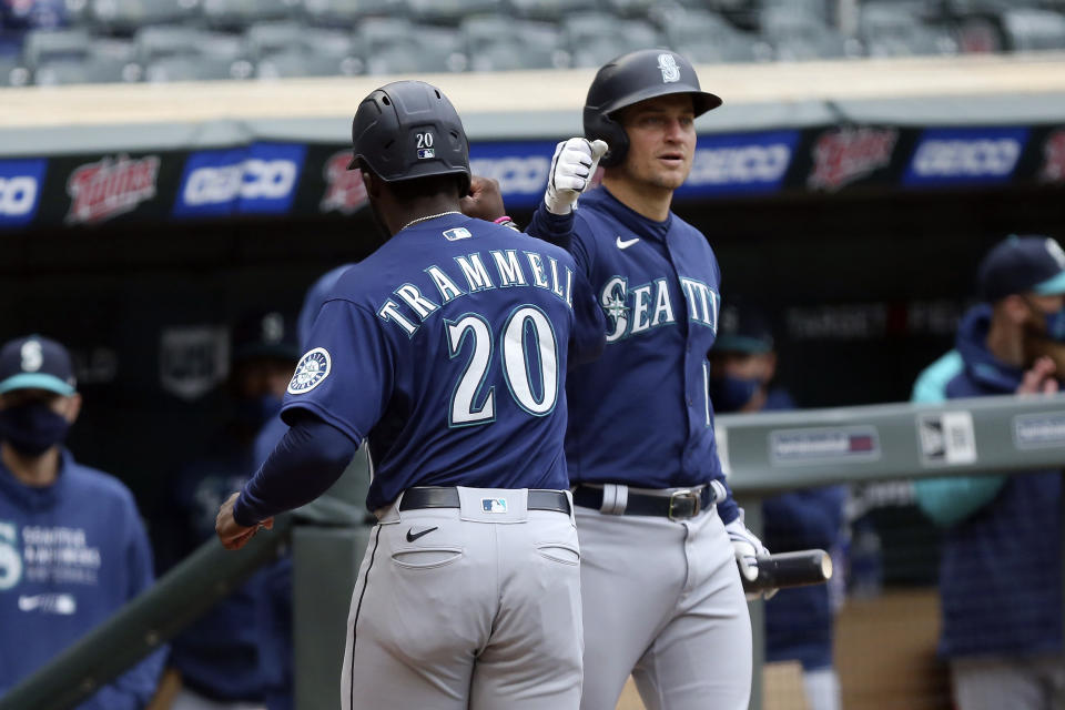 Seattle Mariners' Taylor Trammell (20) is greeted by teammate Kyle Seager (15) after he scored on a sacrifice fly in the tenth inning of a baseball game against Minnesota Twins, Saturday, April 10, 2021, in Minneapolis. Seattle won 4-3 in 10 innings. (AP Photo/Stacy Bengs)