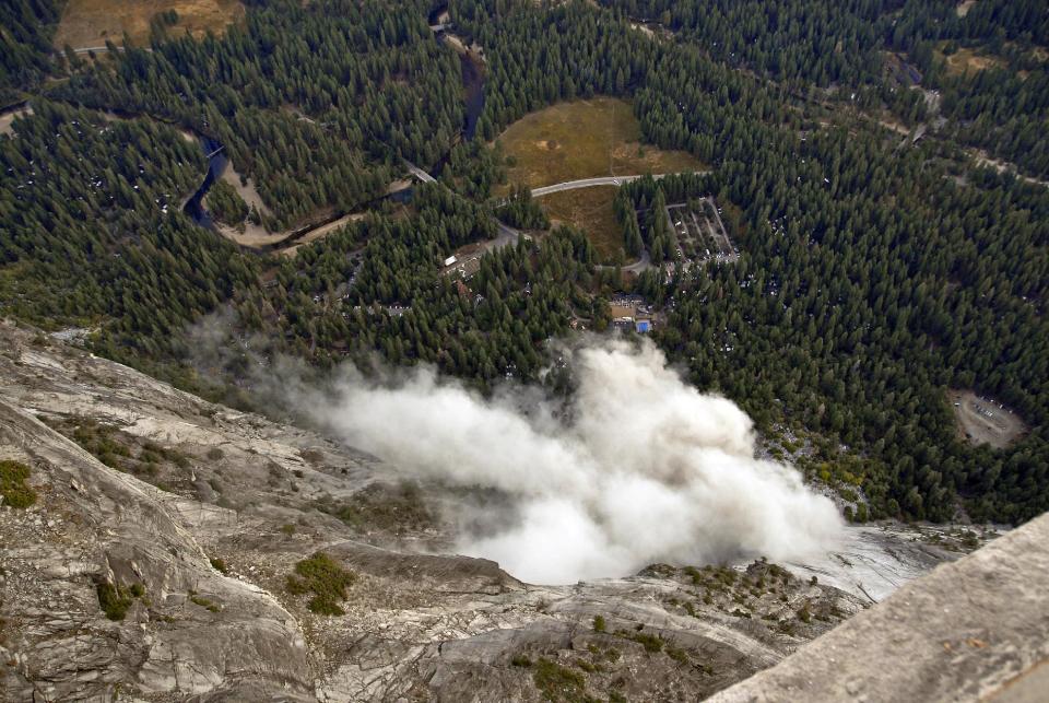 FILE - In this Oct. 8, 2008, file photo, a dust cloud is seen from the Glacier Point overlook during a rock fall that damaged lodging facilities at Curry Village in Yosemite National Park, Calif. Falling boulders are the single biggest force shaping Yosemite Valley, one of the most popular tourist destinations in the nation’s system of national parks. Now large swaths of popular haunts deemed unsafe are closing as officials acknowledge they knew for more than a decade ago that unsuspecting tourists were being lodged in harm’s way. On Thursday, June 14, 2012, the National Park Service will announce that potential danger from the unstable 3,000-foot-tall slab of granite known as Glacier Point, a picturesque promontory that for decades has provided a dramatic backdrop to park entertainment events, will leave uninhabitable large parts of Yosemite Valley’s most popular lodging areas. (AP Photo/Jim Nichols, File)