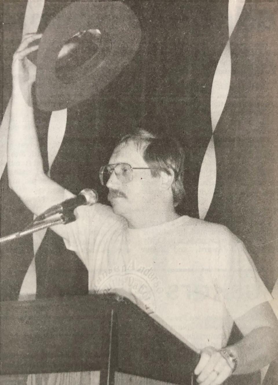 De Smet boys baskeball coach Marv McCune lifts a cowboy hat during a welcome home celebration for the Bulldogs' 1987 state Class B championship team.