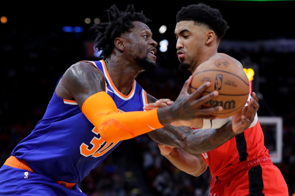 New York Knicks forward Julius Randle, left, is fouled by Houston Rockets forward Kenyon Martin Jr., right, on a drive to the basket during the first half of an NBA basketball game Saturday, Dec. 31, 2022, in Houston. (AP Photo/Michael Wyke)
